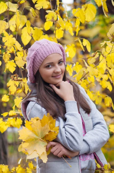 Jeune fille dans un parc en automne avec des feuilles jaunes — Photo