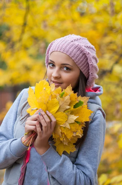 Jeune fille dans un parc en automne avec des feuilles jaunes — Photo