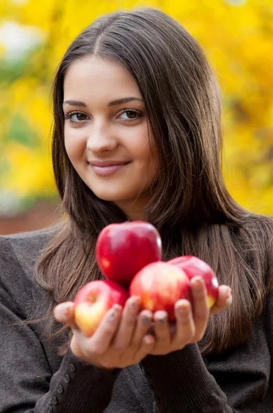 Jong meisje in herfst park met appels — Stockfoto