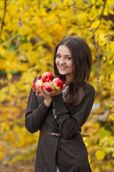 Młoda dziewczyna w parku jesienne z jabłkami — Zdjęcie stockowe