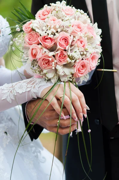 Bride and Groom holding Hands with Rings on Floral Bouquet — Stock Photo, Image