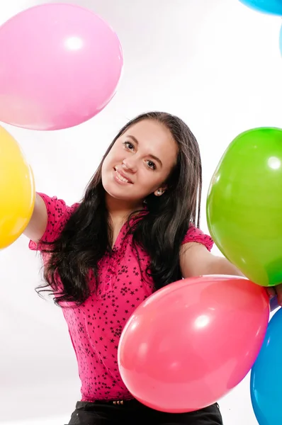 Giovane ragazza con palloncini colorati vivaci su uno sfondo bianco — Foto Stock