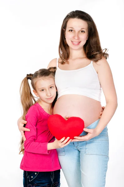 Jonge zwangere vrouw met haar dochter op witte achtergrond — Stockfoto