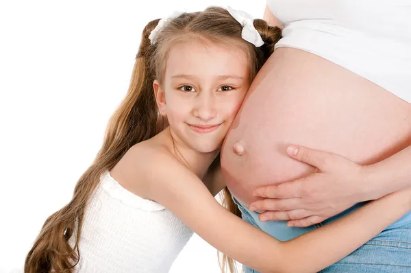 Menina abraçando a barriga grávida de sua mãe — Fotografia de Stock