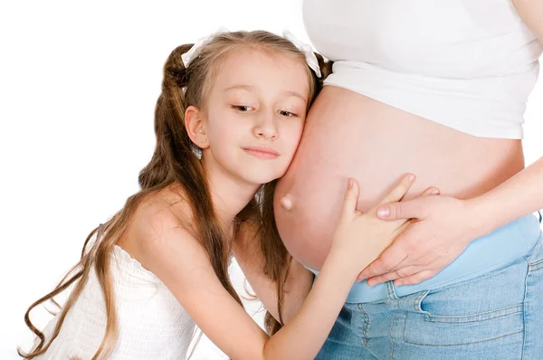 Petite fille étreignant le ventre enceinte de sa mère — Photo