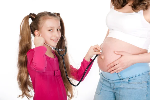 Niño escuchando vientre de la madre embarazada — Foto de Stock