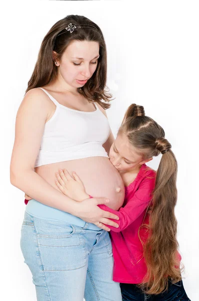 Jonge zwangere vrouw met haar dochter op witte achtergrond — Stockfoto