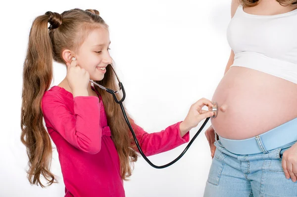 Niño escuchando vientre de la madre embarazada — Foto de Stock