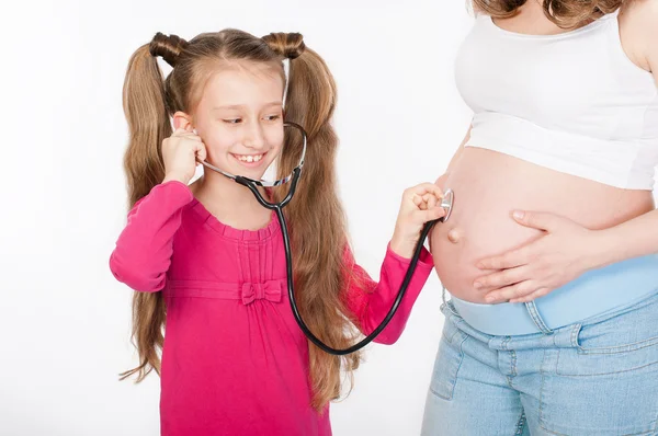 Niño escuchando vientre de la madre embarazada — Foto de Stock