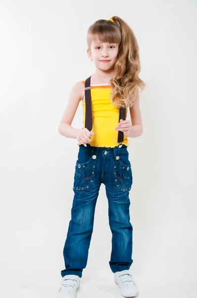 Bambina in jeans su sfondo bianco — Foto Stock