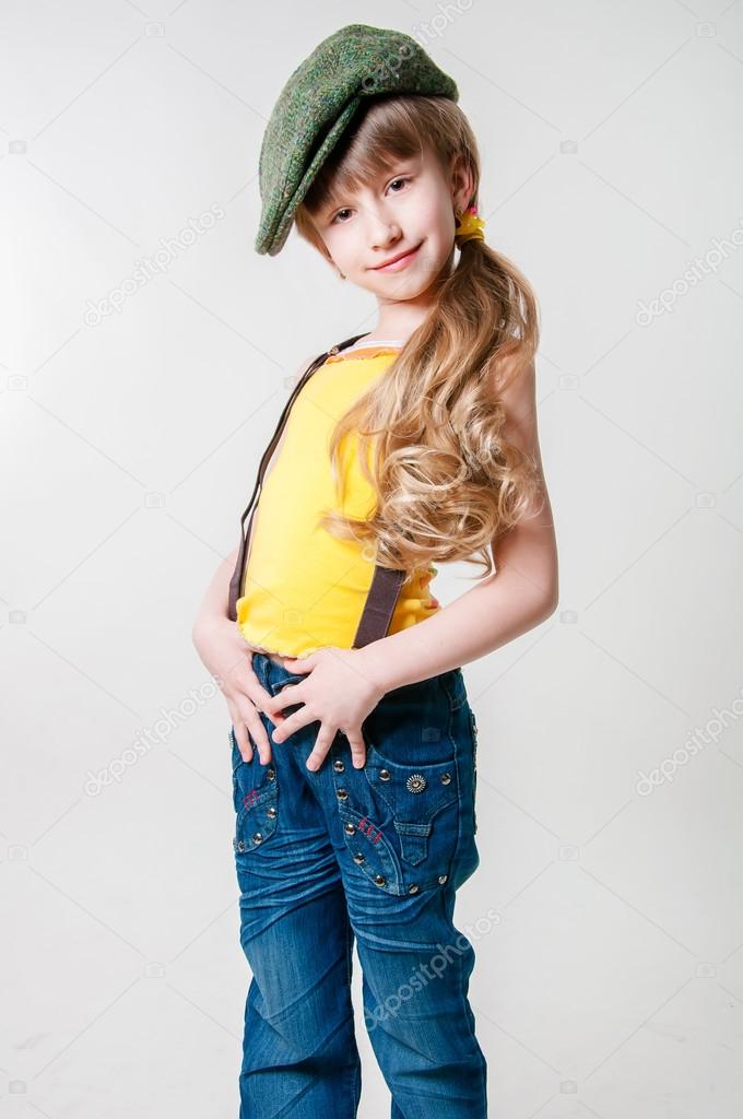 Little girl in jeans on a white background