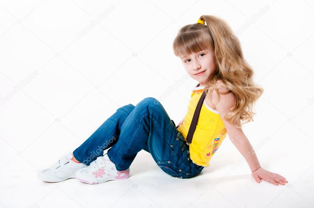 Little girl in jeans on a white background