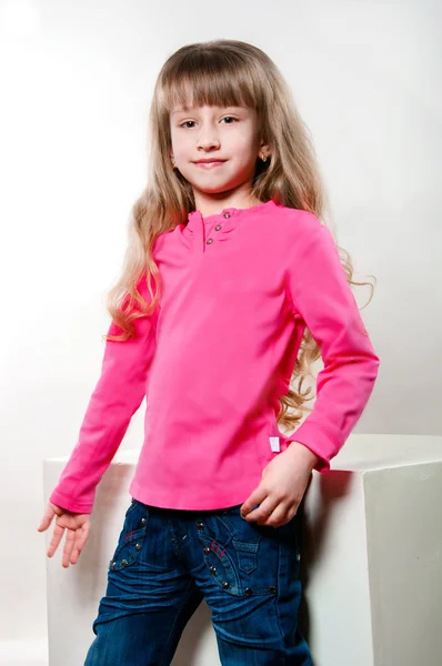Meisje met lang krullend haar in een roze blouse — Stockfoto