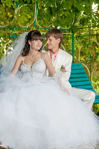 Jeune et belle mariée et marié sur le banc — Photo