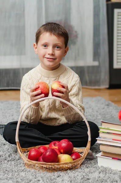Αγόρι με μήλα και βιβλία στο σπίτι — 图库照片