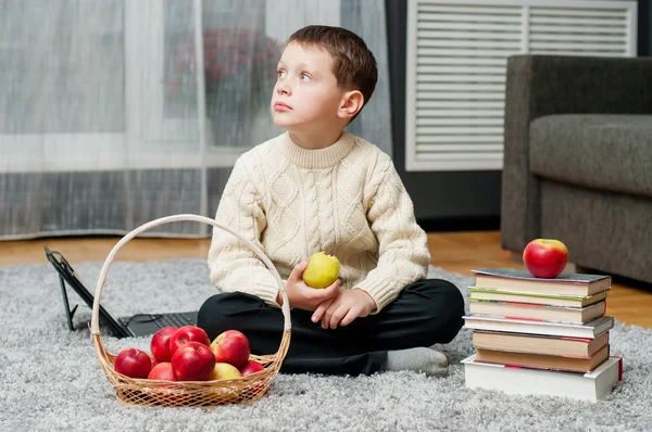 Junge mit Äpfeln und Büchern zu Hause — Stockfoto