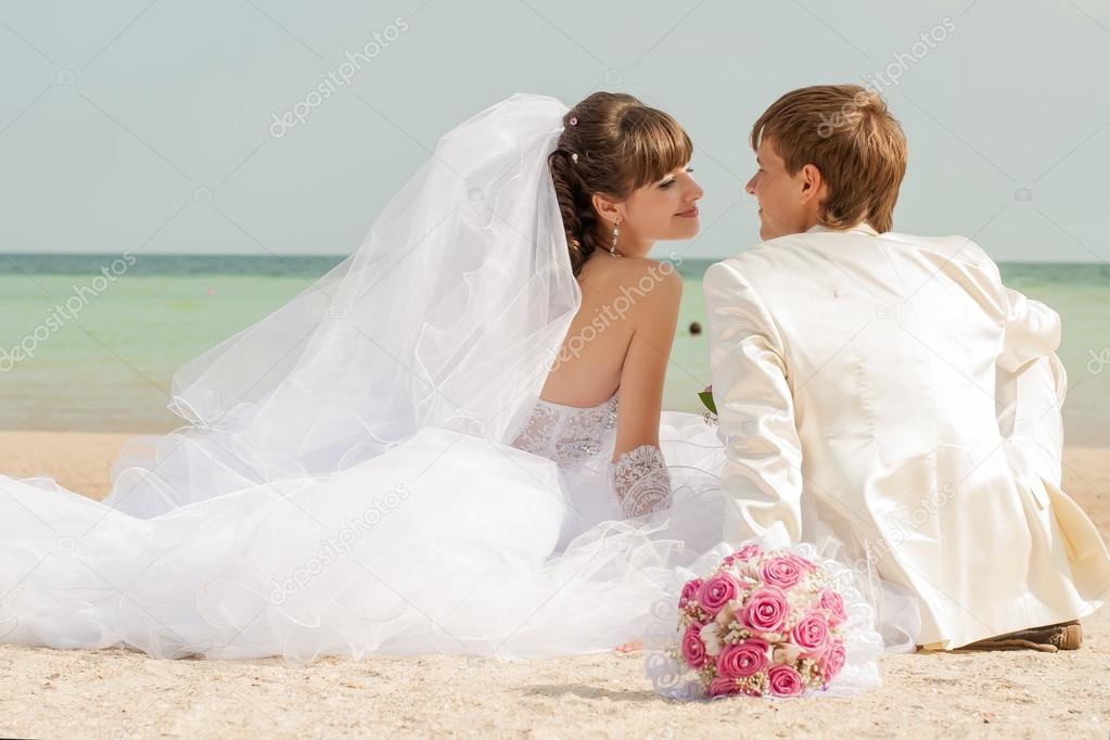 Young and beautiful bride and groom on the beach