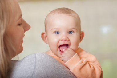 bir bebek tutan genç anne