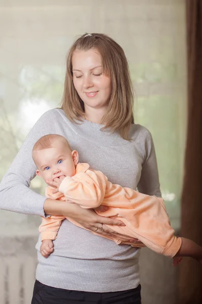 Ung mamma hålla en baby — Stockfoto