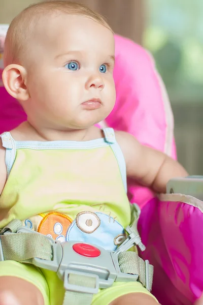 Bambino seduto su una sedia e sorridente — Foto Stock