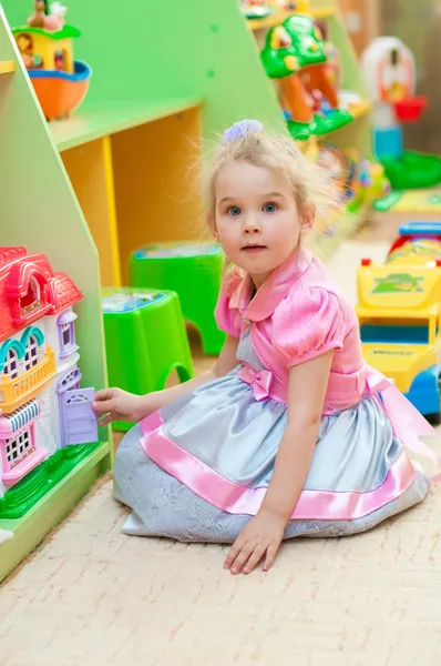 Menina com brinquedos na sala de jogos — Fotografia de Stock