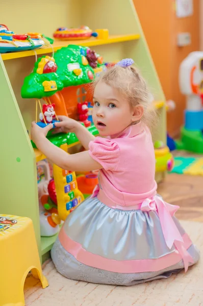 Menina com brinquedos na sala de jogos — Fotografia de Stock