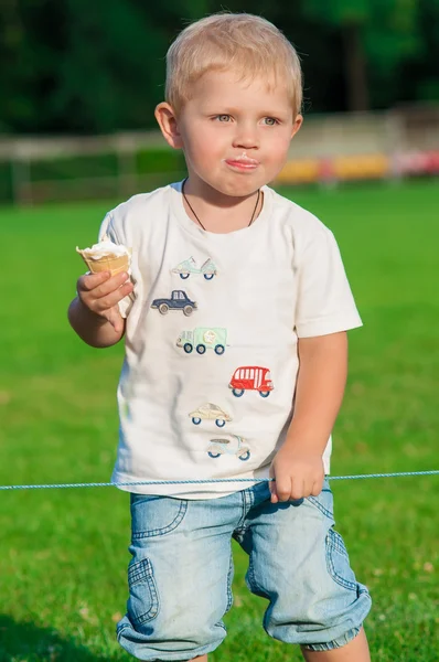 Mały chłopiec jedzący lody w parku — Zdjęcie stockowe