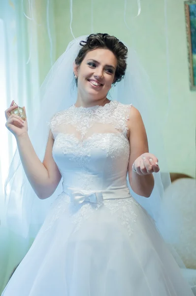 Bela noiva em um vestido de noiva com perfume — Fotografia de Stock