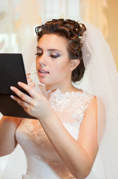 Красивая невеста в свадебном платье с помадой — стоковое фото
