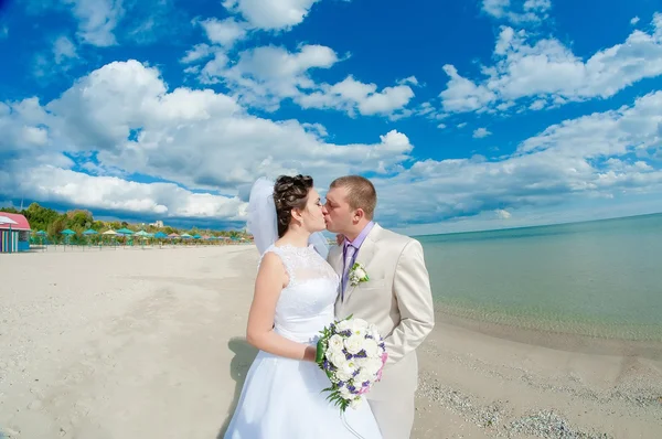 Noiva jovem e bonita e noivo na praia — Fotografia de Stock