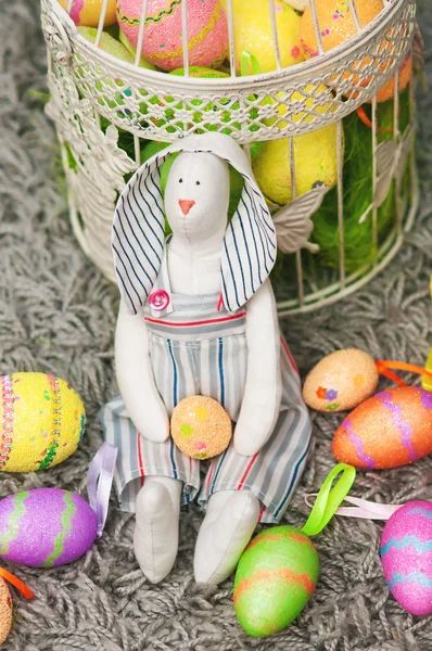 Coelho de brinquedo de Páscoa com ovos coloridos — Fotografia de Stock