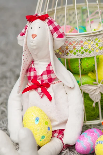 Coelho de brinquedo de Páscoa com ovos coloridos — Fotografia de Stock