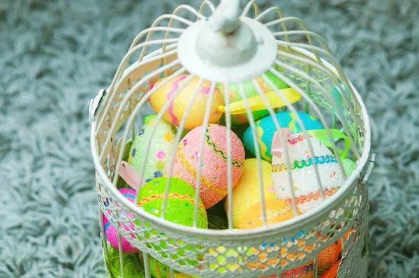 Gaiola decorativa com ovos de Páscoa pintados — Fotografia de Stock
