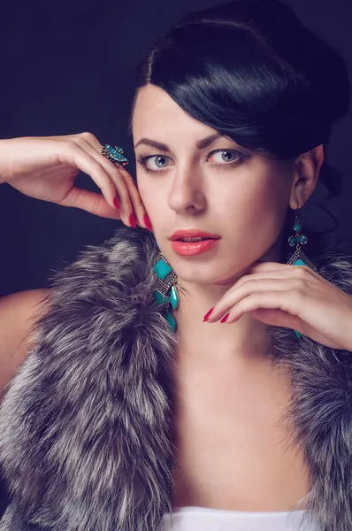 Young woman in a fur coat in  earrings — Stock Photo, Image