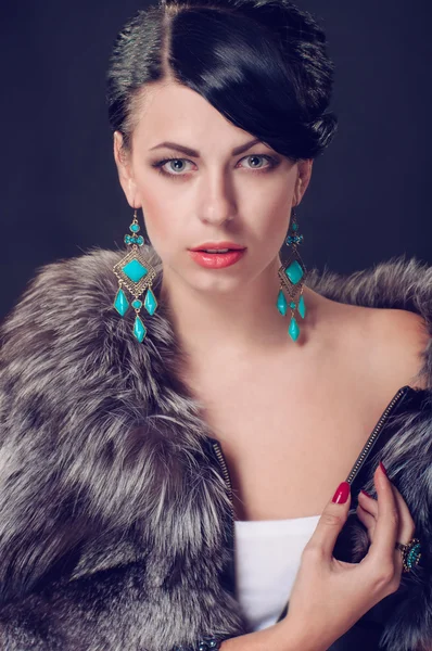 Young woman in a fur coat in  earrings — Stock Photo, Image