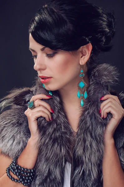 Young woman in a fur coat in  earrings — Stock Photo, Image