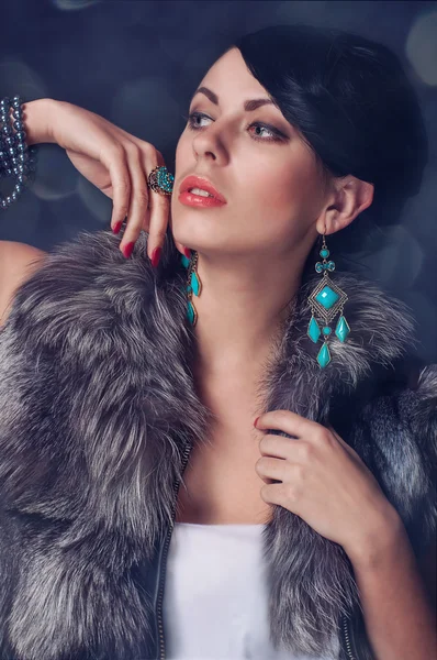 Young woman in a fur coat in  earrings — Stock Photo, Image