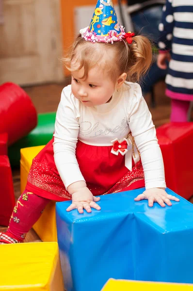 Klein meisje spelen met speelgoed in de speelkamer — Stockfoto