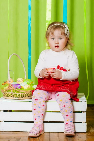 Liten flicka med en korg med påskägg — Stockfoto