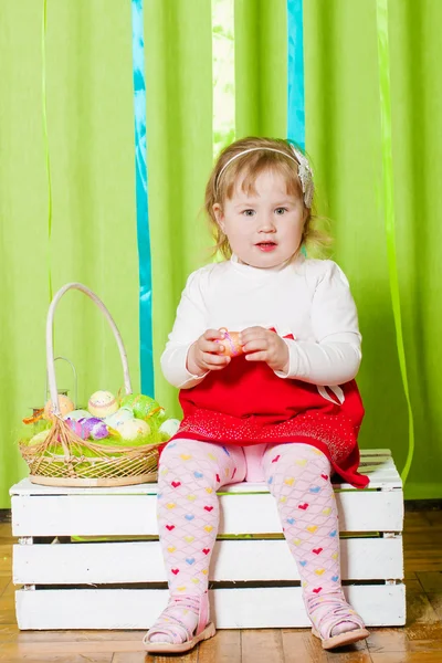 Kleines Mädchen mit einem Korb mit Ostereiern — Stockfoto