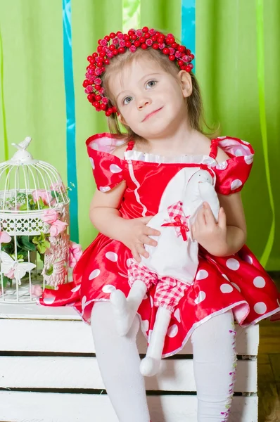 Menina bonita em um vestido vermelho e coroa de bagas vermelhas — Fotografia de Stock