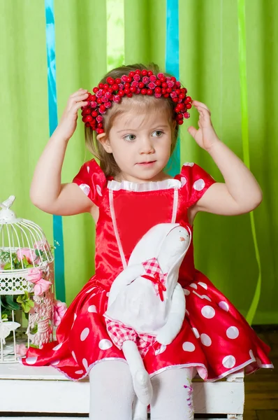 Beautiful girl in a red dress and  wreath of red berries — Stock Photo, Image