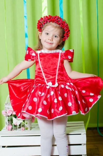 Menina bonita em um vestido vermelho e coroa de bagas vermelhas — Fotografia de Stock