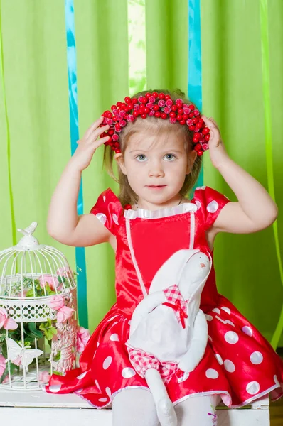 Schöne Mädchen in einem roten Kleid und Kranz aus roten Beeren — Stockfoto