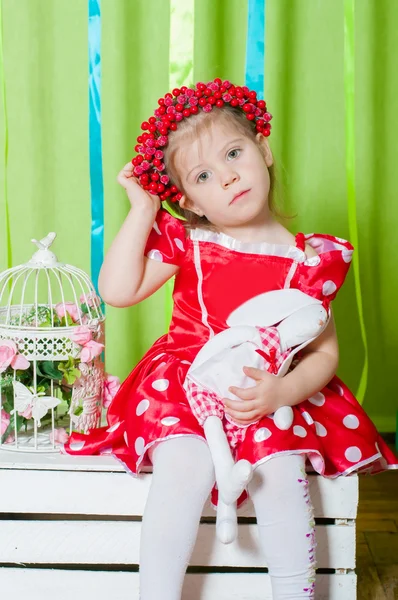 Menina bonita em um vestido vermelho e coroa de bagas vermelhas — Fotografia de Stock