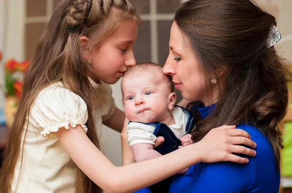 Mamma abbraccia bambino e figlia maggiore — Foto Stock