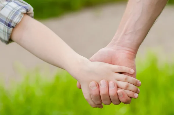 Hands of father and child in nature — Stock Photo, Image