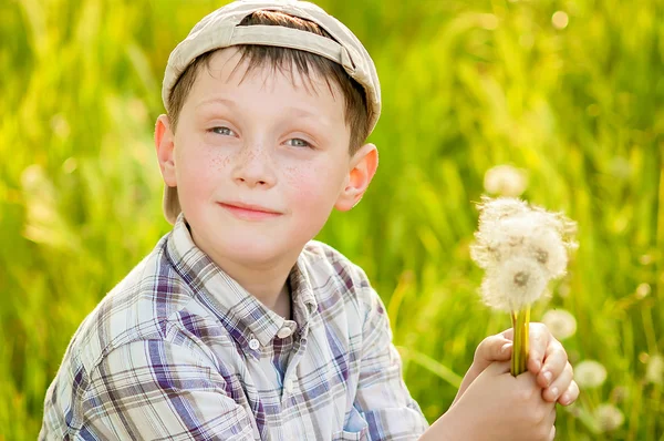 Boy on summer nature with dandelions — Stock Photo, Image