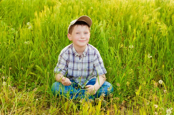 Boy on summer nature with dandelions — Stock Photo, Image