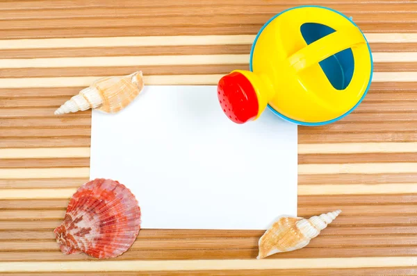 Paper card  and seashells toy shovel on wood — Stock Photo, Image